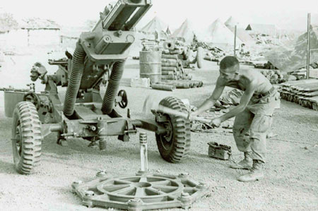 An artilleryman pounds in stakes while emplacing his crew's gun